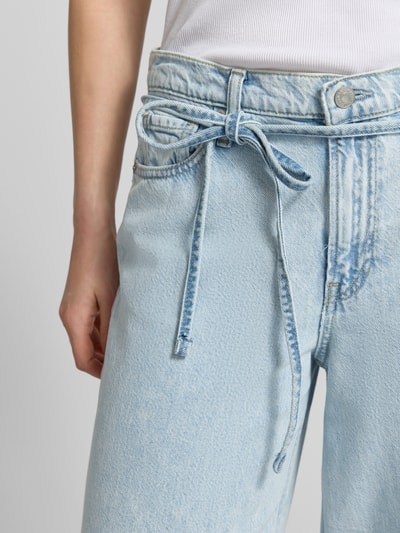 Frauenmodel trägt Baggy Jeans mit Bindegürtel von GAP in hellem Blau, Baumwoll-Lyocell-Mix, Eingrifftaschen, Nahaufnahme Oberkörper.