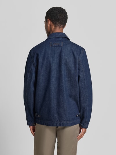 Männermodel trägt Regular Fit Jeansjacke aus reiner Baumwolle Modell 'WORK' von GANT in dunklem Blau, Rückenansicht Ganzkörperansicht. Kontext: Herren Jeansjacke mit Umlegekragen, durchgehende Knopfleiste, aufgesetzte Eingriff- und Brusttaschen, Label-Patch, Rückenlänge 71 cm, Schulterbreite 44 cm, Brustweite 51 cm, Ärmellänge 65 cm.