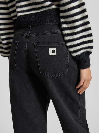 Frauenmodel trägt Jeans mit weitem Bein Modell 'Brandon' von Carhartt Work In Progress aus reiner Baumwolle mit Eingrifftaschen, Nahaufnahme Rückansicht.