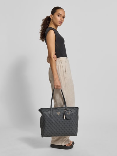 Vrouwenmodel draagt shopper met logomotief model 'ECO POWER PLAY II' van guess, hoofdvak met ritssluiting, draagband, uitneembare binnenzak, breedte 46 cm, lengte 31 cm, diepte 15 cm, schouderband 60 cm, zijaanzicht heuphoogte