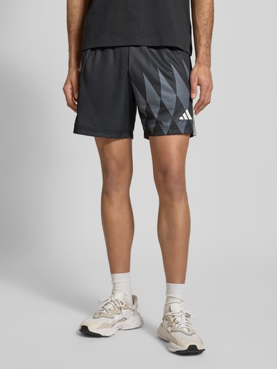 Männermodel trägt Regular Fit Shorts mit Logo-Print Modell 'Tiro' von adidas Sportswear, Herren, elastischer Bund, Ganzkörperansicht von vorne.