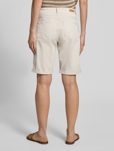 Frauenmodel trägt Bermudas mit Umschlag und Eingrifftaschen von Angels in hellem Beige, Regular-Fit, Ganzkörperansicht Rückansicht, Bundweite bei Größe 36: 40 cm, Innenbeinlänge bei Größe 36: 25 cm, sichtbare Textur und Form.