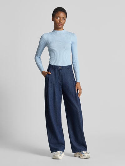Frauenmodel trägt Slim Fit Pullover aus reiner Baumwolle Modell 'ALAANIA' von ARMEDANGELS in Hellblau, dezente Rippstruktur, Ganzkörperansicht von vorne. Damen Pullover von ARMEDANGELS.