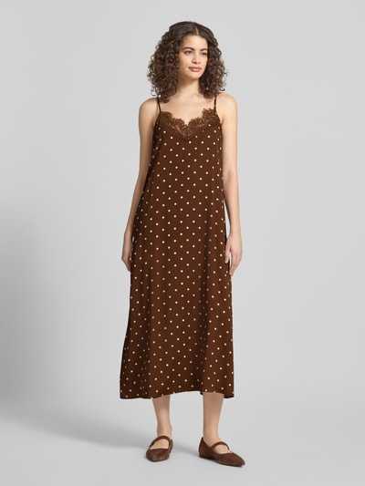 Kobiece model prezentuje Relaxed Fit Maxikleid aus Viskose-Mix Modell 'Alma' von OH APRIL, brązowa z żółtymi kropkami, obszycie koronką, cienkie ramiączka, dekolt w serek, długość tyłu 107 cm, szerokość w rozmiarze S 45 cm, Ganzkörperansicht von vorne.
