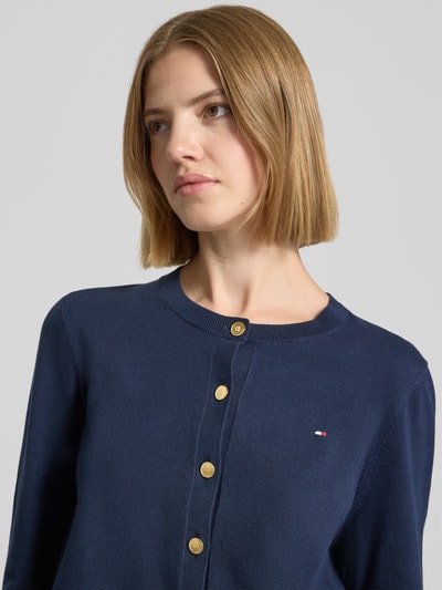 Kobieta nosi Regular Fit Strickjacke aus Baumwoll-Mix mit goldenen Knöpfen od Tommy Hilfiger w kolorze granatowym, Nahaufnahme górnej części ciała.