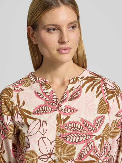 Frauenmodel trägt Regular Fit Bluse mit floralem Allover-Print von Soyaconcept aus reiner Baumwolle mit Tunika-Ausschnitt, Nahaufnahme Oberkörper.