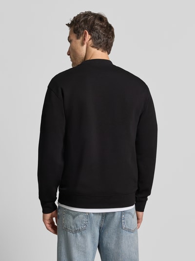 Männermodel trägt Slim Fit Pullover aus reiner katoen 'TOM' van Selected, zwart, eenvoudige vormen, gladde textuur, Ganzkörperansicht Rückansicht.
