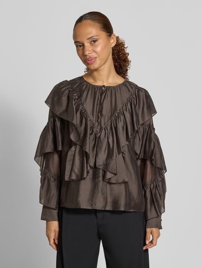 Frauenmodel trägt Regular Fit Bluse aus Lyocell-Mix von COMMA in Dunkelbraun mit Rüschenbesatz und Rundhalsausschnitt, Nahaufnahme Oberkörper. Rückenlänge 52 cm, Ärmellänge 59 cm.