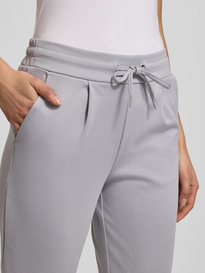 Frauenmodel trägt Stoffhose mit elastischem Bund Modell 'KATE' von ICHI, hellgrauer Material-Mix, Tunnelzug, Nahaufnahme Oberkörper.