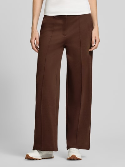 Frauenmodel trägt Wide Fit Hose mit Viskose-Anteil Modell 'Kate' von ICHI in Dunkelbraun, elastischer Material-Mix, Ziernähte, Nahaufnahme Oberkörper.