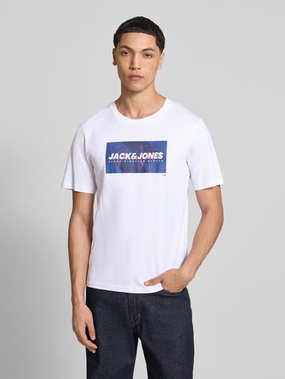 Männermodel trägt Regular Fit T-Shirt aus reiner Baumwolle Modell 'COLE' von Jack & Jones mit Label-Print, Rundhalsausschnitt, Herren T-Shirt, Ganzkörperansicht von vorne.
