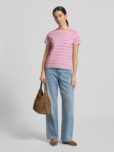 Frauenmodel trägt Regular Fit T-Shirt aus reiner Baumwolle von Tom Tailor Denim in mehrfarbigem Streifenmuster, Jersey-Textur, Label Stitching, Rundhalsausschnitt, kurzarm, kombiniert mit Jeans; Ganzkörperansicht von vorne.