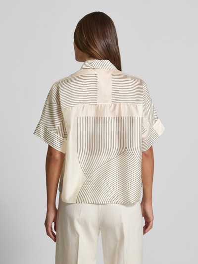 Vrouwenmodel draagt Boxy Fit blouse uit lyocellmix model 'Zulin' van Someday met overhemdkraag en bedekte knoopsluiting, ruglengte maat 36: 60 cm, mouwlengte maat 36: 20 cm, crème met zwarte lijnen, structuur glad, boxy fit vorm, geheel van achteren.