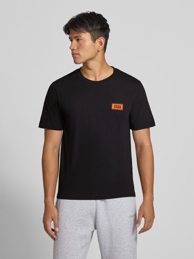 Männermodel trägt Regular Fit T-Shirt aus reiner Baumwolle mit Label-Detail von JACK & JONES, Schwarz, Nahaufnahme Oberkörper.