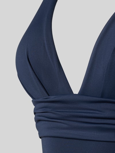 Frauenmodel trägt Body mit V-Ausschnitt von Seafolly in Dunkelblau, Material-Mix, körpernah mit Raffungen, Nahaufnahme Oberkörper.