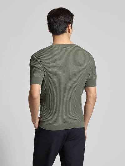 Männermodel trägt Slim Fit T-Shirt mit Viskose-Anteil von Antony Morato in Olivgrün, Strick-Optik, elastische Ärmel, Ganzkörperansicht Rückansicht.