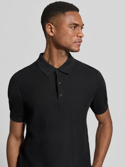 Männermodel trägt Regular Fit Poloshirt aus reiner Baumwolle von Strellson in Schwarz, Strickoptik, Strukturmuster, Nahaufnahme Oberkörper.
