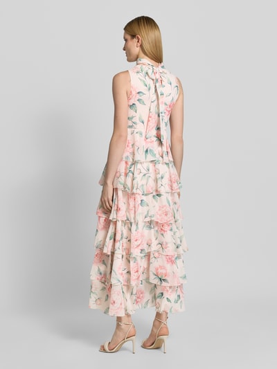 Vrouwenmodel draagt meerkleurig, getailleerd dames vrijetijdsjurk met bloemenmotief, volants en chiffonmateriaal, model 'FELICIA' van Vero Moda. Ganzkörperansicht Rückansicht.