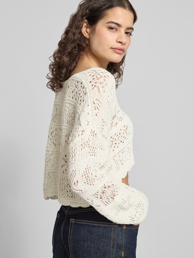 Kobiece modelka ma na sobie Cropped Strickjacke aus recyceltem Baumwoll-Mix Modell 'BEACH LIFE' von ONLY, ażurowy wzór, krój relaxed fit, taśma do wiązania, dekolt w serek, długi rękaw, faliste wykończenie, dzianina z mieszanki bawełny z recyklingu, efekt: jednolity kolor, widok całego ciała z przodu
