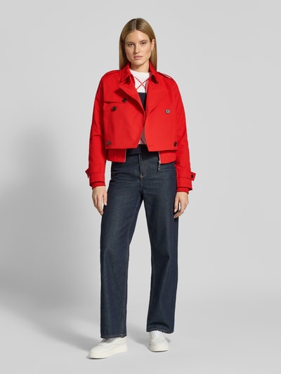 Vrouwenmodel draagt Trenchcoat mit Ärmelriegeln van monari in regular fit, rood, knoopsluiting, omgeslagen kraag, vooraanzicht, geheel lichaam.