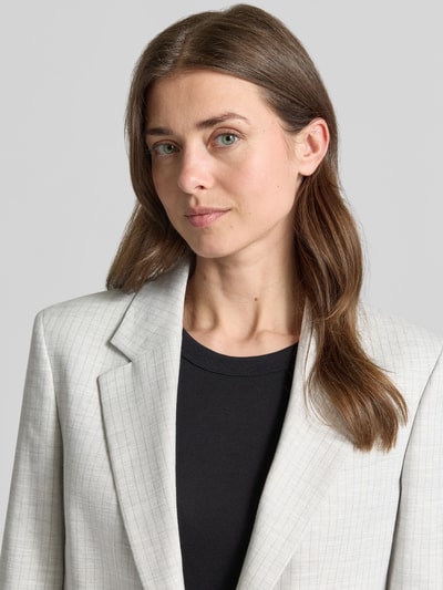 Vrouwenmodel draagt Regular Fit Longblazer uit linnenmix model 'ANETTEA' van HUGO met krijtstreep, reverskraag, melange look, twillstructuur, detailopname bovenlichaam.