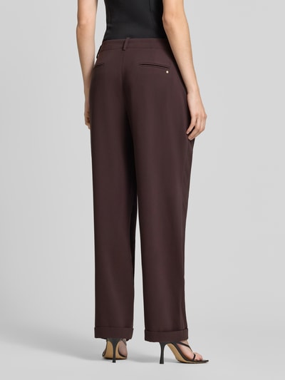 Frauenmodel trägt Relaxed Fit Stoffhose mit Kellerfalten von Armani Exchange in dunklem Braun, Taschen, umgeschlagene Beinabschlüsse, Ganzkörperansicht Rückansicht. Damen Stoffhose von Armani, Knopf- und Reißverschluss, Bundweite bei Größe 36: 42 cm, Innenbeinlänge: 78 cm.