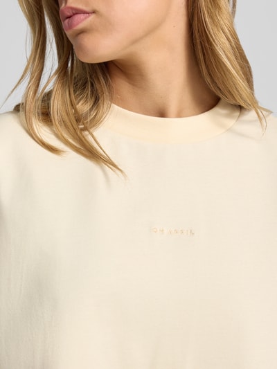 Frauenmodel trägt T-Shirt mit Logo-Stitching Modell 'Ella' von OH APRIL, reine Baumwolle, Boxy Fit, Nahaufnahme Oberkörper.
