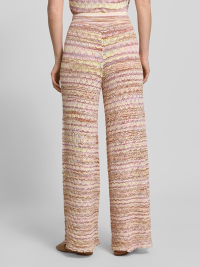 Frauenmodel trägt Hose aus Viskose-Mix im Allover-Look von Christian Berg Woman, pastellfarbene Muster, elastischer Bund, Ganzkörperansicht Rückansicht.