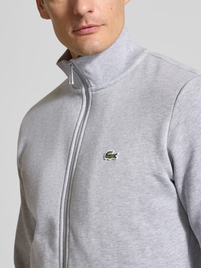 Männermodel trägt Regular Fit Sweatjacke aus Baumwoll-Mix von Lacoste, Optik: Unifarben, Logo-Patch, Stehkragen, Nahaufnahme Oberkörper.