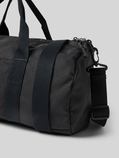 Produktfoto, Weekender mit Label-Stitching von CK Calvin Klein, czarny materiał, srebrny zamek, odpinany pasek, prostokątny kształt, kontekst: torba męska z główną komorą na zamek, uchwyty, odpinany pasek na ramię 90 cm, kieszeń wewnętrzna na zamek, wymiary 45x24x22 cm.