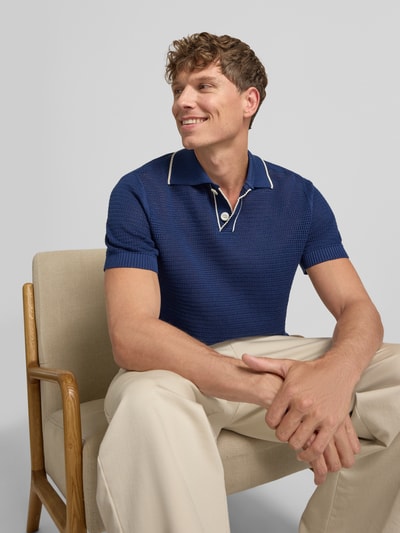 Männermodel trägt Regular-Fit Poloshirt aus reiner Baumwolle Modell 'JESSE' von Selected Homme in Dunkelblau, Nahaufnahme Oberkörper. Herren Poloshirt.