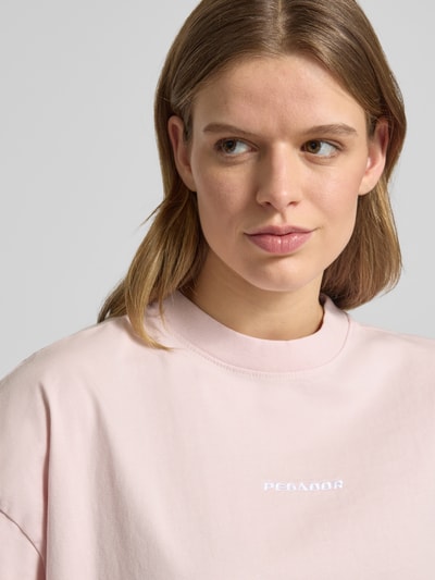 Frauenmodel trägt Oversized Fit Damen T-Shirt mit Label-Stitching Modell 'BRACY' von Pegador in Rosa aus Reine Baumwolle, Nahaufnahme Oberkörper.