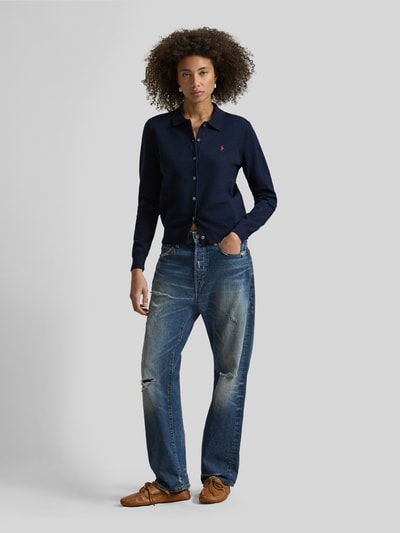 Frauenmodel trägt Slim Fit Strickjacke aus Baumwoll-Mix von Polo Ralph Lauren in Dunkelblau mit Knopfleiste und Logo-Stitching, Ganzkörperansicht von vorne.