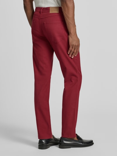 Mannenmodel draagt Slim Fit Jeans im 5-Pocket-Design van Christian Berg Men in rood, katoenmix, slim fit, 5-pocketmodel, knoop- en ritssluiting, bandwijdte maat 32/32: 42 cm, binnenbeenlengte maat 32/32: 82 cm, geheellichaamsaanzicht achteraan.
