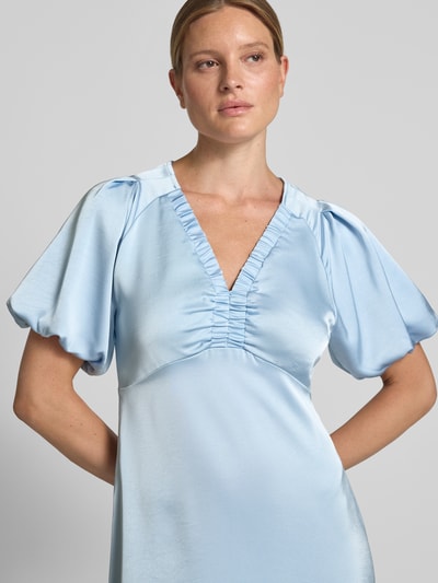 Frauenmodel trägt Midikleid aus Satin Modell 'Illana' von Neo Noir in Hellblau mit V-Ausschnitt, taillierter Passform und Raffungen, Nahaufnahme Oberkörper.