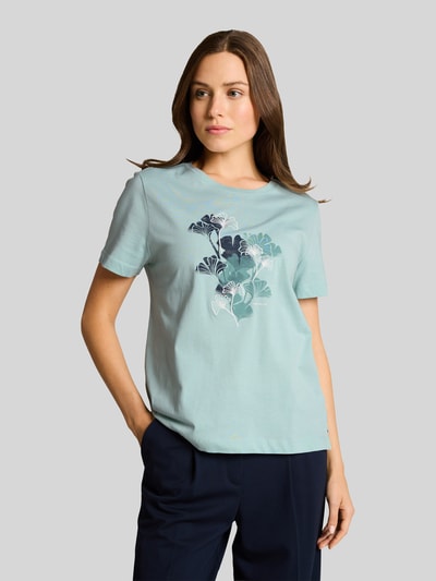 Frauenmodel trägt Regular Fit T-Shirt aus reiner Baumwolle von Tom Tailor, Optik: Unifarben, Motiv-Print-Stitching, Jersey, Ganzkörperansicht von vorne.