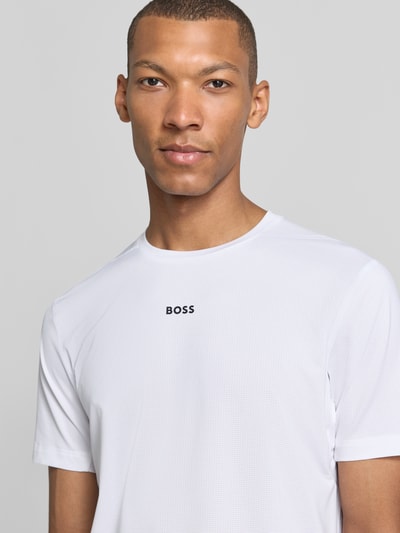 Männermodel trägt weißes Slim Fit Sport-T-Shirt mit Label-Print Modell 'TS_Active' von BOSS Green, dezente Struktur, Nahaufnahme Oberkörper.