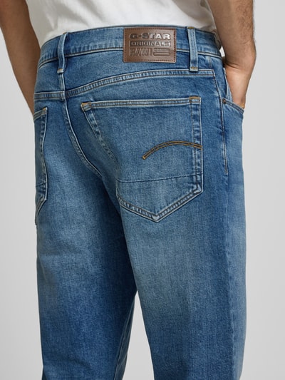 Männermodel trägt Regular Tapered Fit Jeans im Used Look Modell '3301' von G-Star Raw aus Baumwoll-Elasthan-Mix, Eingrifftaschen, Nahaufnahme Rückansicht, Bundweite 43 cm, Innenbeinlänge 79 cm.