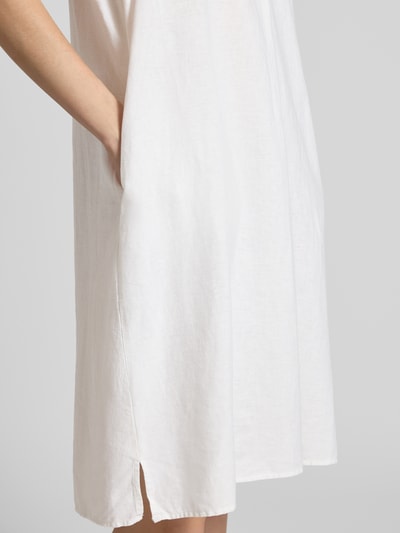 Frauenmodel trägt Knielanges Leinenkleid mit V-Ausschnitt Modell 'Ina' von Soyaconcept, Leinen-Mix mit Viskose-Anteil, Seitliche Schlitze, Loose-Fit, weiß, glatte Textur, Ganzkörperansicht von vorne.