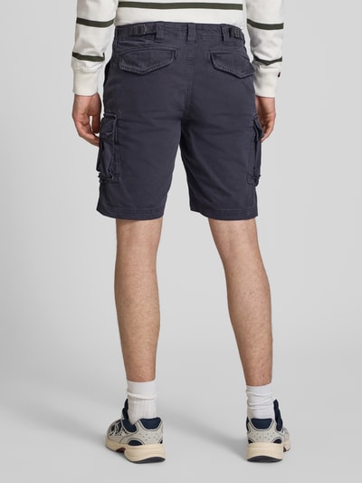 Männermodel trägt Straight Fit Shorts mit Cargo-Taschen Modell 'Core' von Superdry in Dunkelblau, Baumwoll-Mix, Ganzkörperansicht Rückansicht. Shorts mit Eingriffstaschen, Gesäßtaschen, Cargo-Taschen, Knopf- und Reißverschluss, Bundweite 42 cm, Innenbeinlänge 23 cm, für Herren.