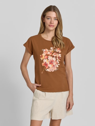 Frauenmodel trägt Damen T-Shirt mit Motiv-Print Modell 'RINA' von Soyaconcept in Braun, Baumwoll-Elasthan-Mix, Regular-Fit, Rundhalsausschnitt, Motiv-Print mit Blumen, Ärmel mit Aufschlag, Rückenlänge bei Größe S 61 cm, Ganzkörperansicht von vorne.