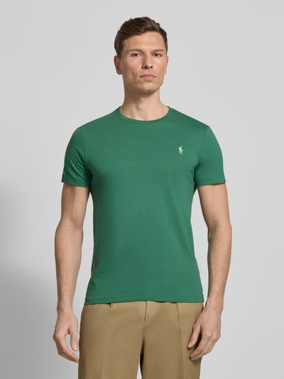 Männermodel trägt Regular Fit T-Shirt aus reiner Baumwolle von Polo Ralph Lauren in Uni-Grün mit Logo-Stitching, Ganzkörperansicht von vorne.