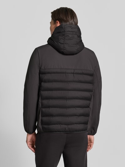 Männermodel trägt Regular Fit Steppjacke mit abnehmbarer Kapuze von Tom Tailor Denim in Schwarz, Ganzkörperansicht Rückansicht, Herren Daunenjacke von Tom Tailor Denim.