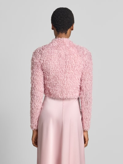 Frauenmodel trägt Cropped Jacke aus Effektgarn mit V-Ausschnitt von SWING in Rosa, Slim Fit, strukturierte Oberfläche, Ganzkörperansicht Rückansicht.
