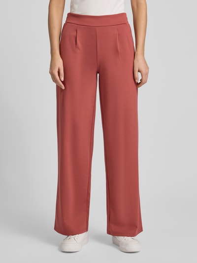 Frauenmodel trägt Wide Fit Stoffhose mit Viskose-Anteil Modell 'Kate' von ICHI in Rot, Bundfalten, Elastischer-Material-Mix, Ganzkörperansicht von vorne.