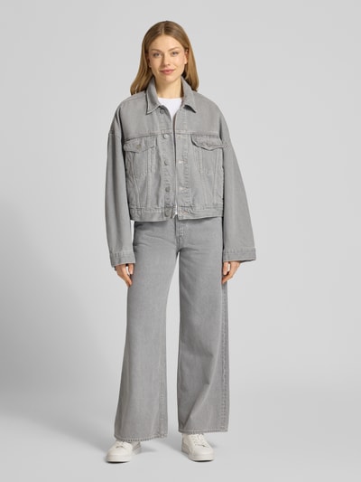 Frauenmodel trägt Oversized Jeansjacke aus Lyocell-Baumwoll-Mix Modell 'PAASITHE' von Armedangels in hellem Denim, Ganzkörperansicht von vorne.