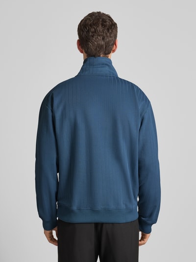 Männermodel trägt Regular Fit Sweatjacke aus Baumwoll-Mix Modell 'DAVRONTO' von HUGO in Unifarben mit Streifenmuster, Ganzkörperansicht Rückansicht.