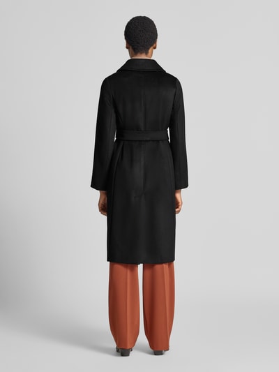 Vrouwenmodel draagt zwarte lange jas van scheerwol, Gerader Mantel aus reiner Schurwolle model 'BCOLLAG' van Max Mara Studio, volledige lichaamsaanzicht achterkant.