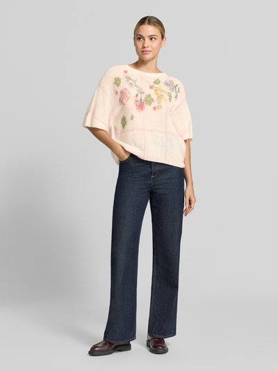 Kobiece model prezentuje Relaxed Fit Pullover aus Alpaka-Mix von Marc Cain, Mieszanka wełny z alpaki z dodatkiem wełny, Imitacja dzianiny, dekolt w serek, rękaw o dł. 1/2, długość tyłu w rozmiarze 36: 53 cm, długość rękawów w rozmiarze 36: 38 cm, jasne kolory z kwiatowym wzorem, szerokie nogawki, widok całej sylwetki z przodu.
