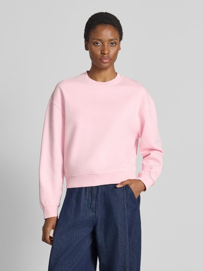 Frauenmodel trägt Relaxed Fit Sweatshirt aus reiner Baumwolle Modell 'Avan' von Samsøe Samsøe in Hellrosa mit elastischen Abschlüssen, Nahaufnahme Oberkörper.